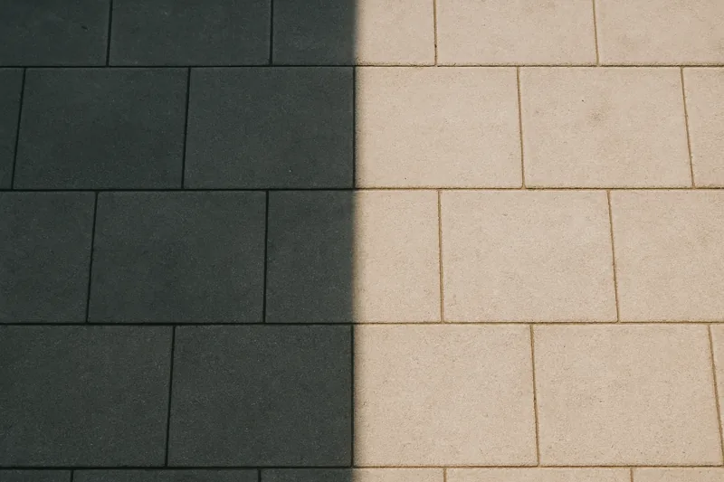 A hard-edged line of shade falling across a plain paved patio floor — patio cover, Longview. Illustrative example.