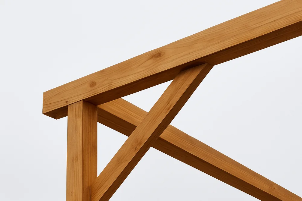 The corner of an open timber patio cover frame seen from below against a pale sky — patio cover, Longview. Illustrative example.